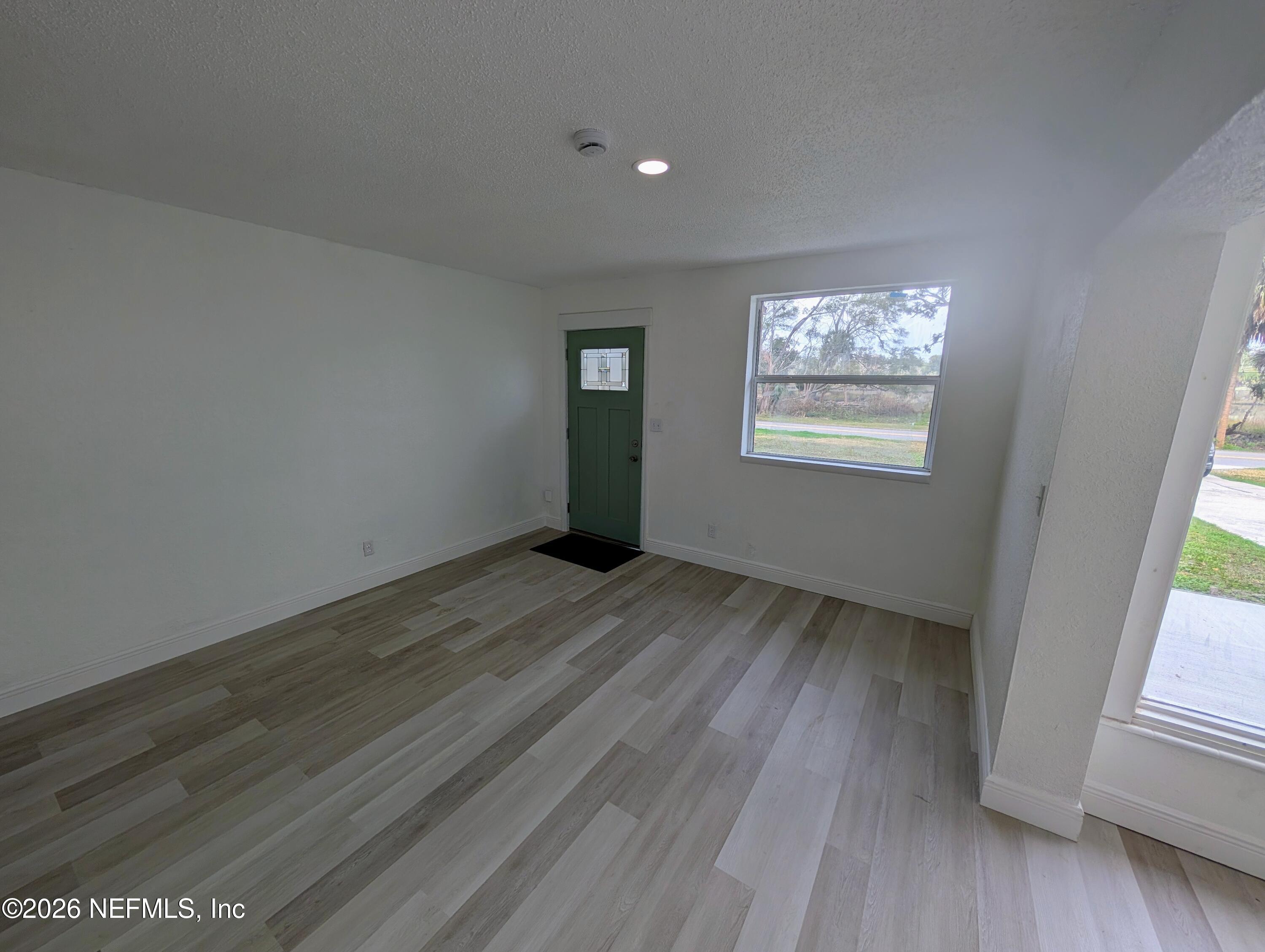1454 Ribault Scenic Drive Jacksonville, FL 32208 - Photo 2 of 22 a view of an empty room with wooden floor and a window