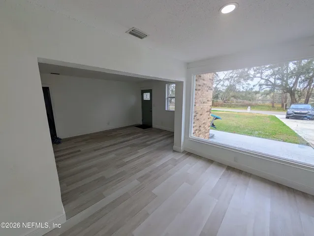 a view of room with window and wooden floor