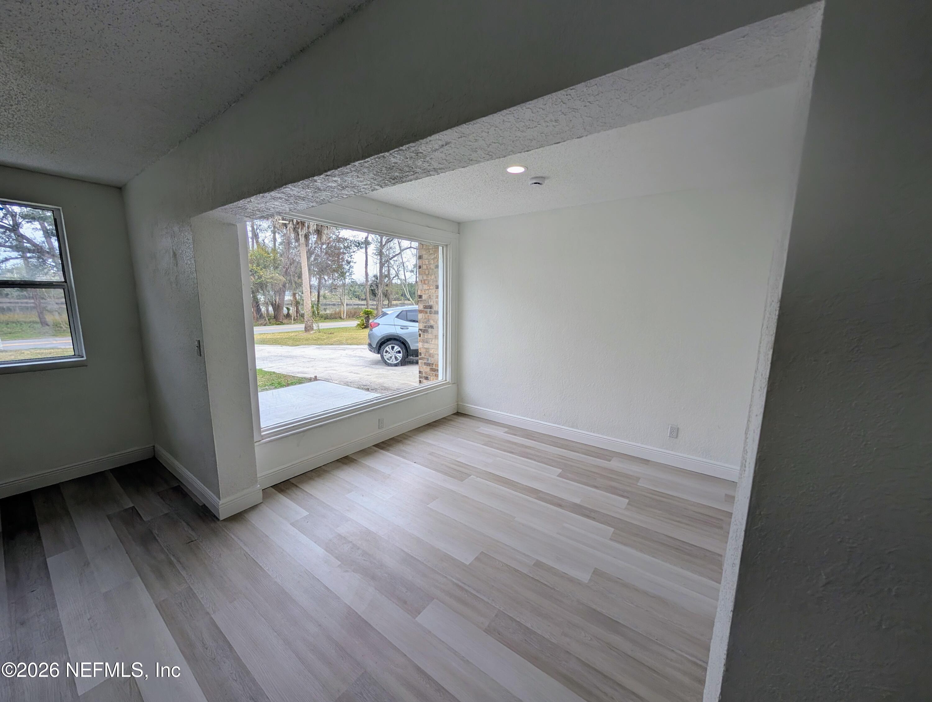1454 Ribault Scenic Drive Jacksonville, FL 32208 - Photo 4 of 22 an empty room with wooden floor and windows