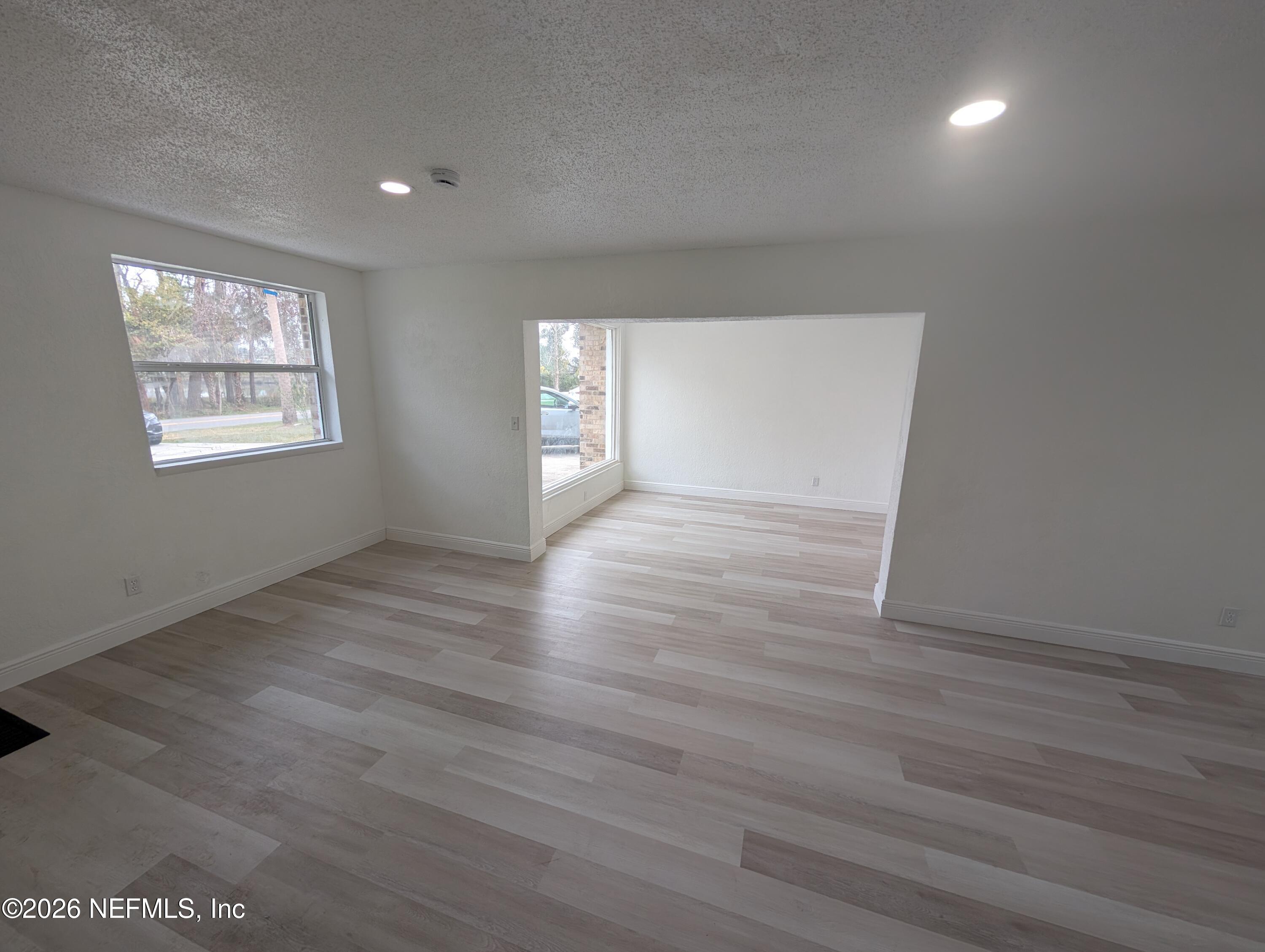 1454 Ribault Scenic Drive Jacksonville, FL 32208 - Photo 5 of 22 an empty room with wooden floor and windows
