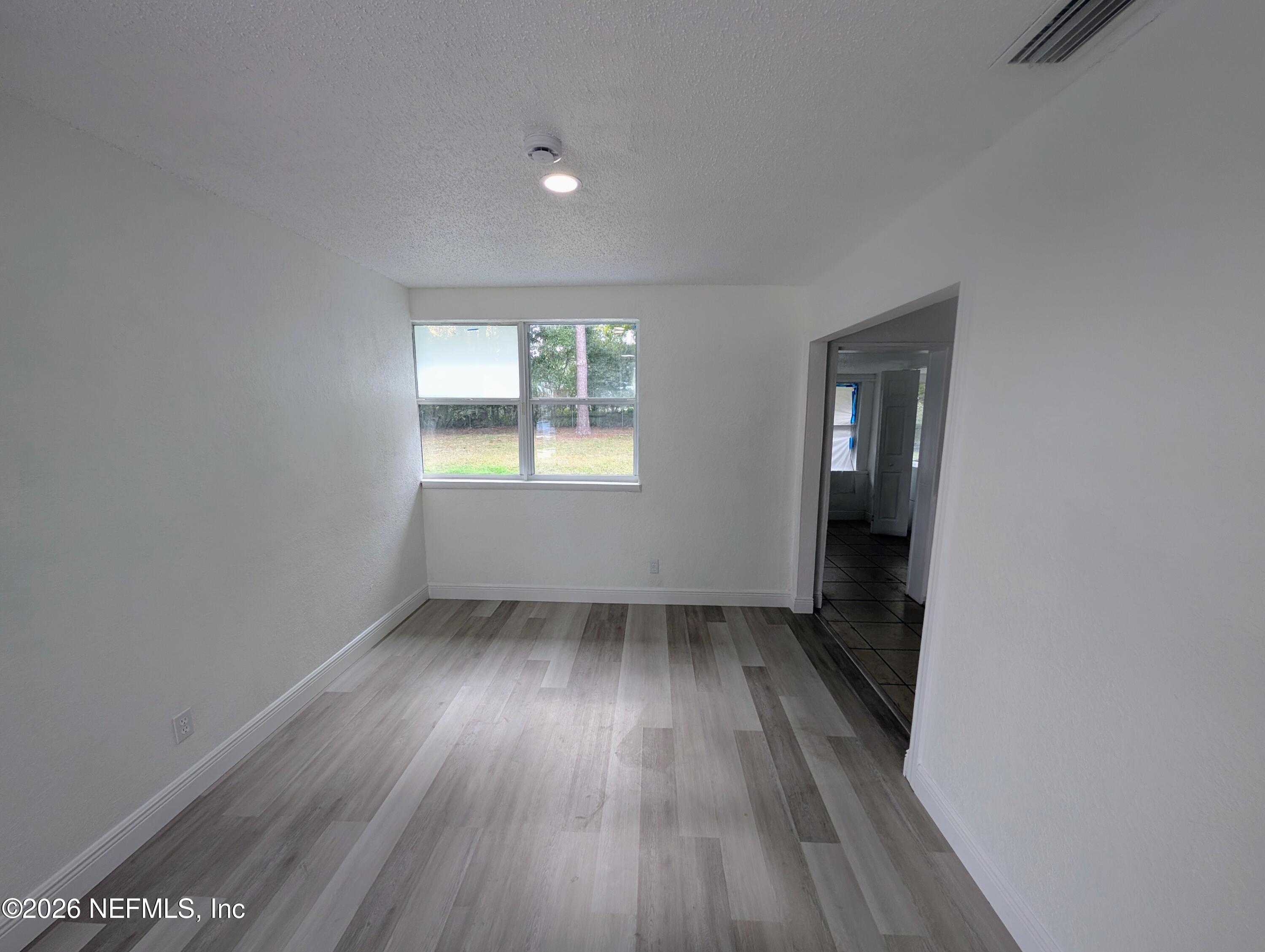 1454 Ribault Scenic Drive Jacksonville, FL 32208 - Photo 6 of 22 an empty room with wooden floor and windows