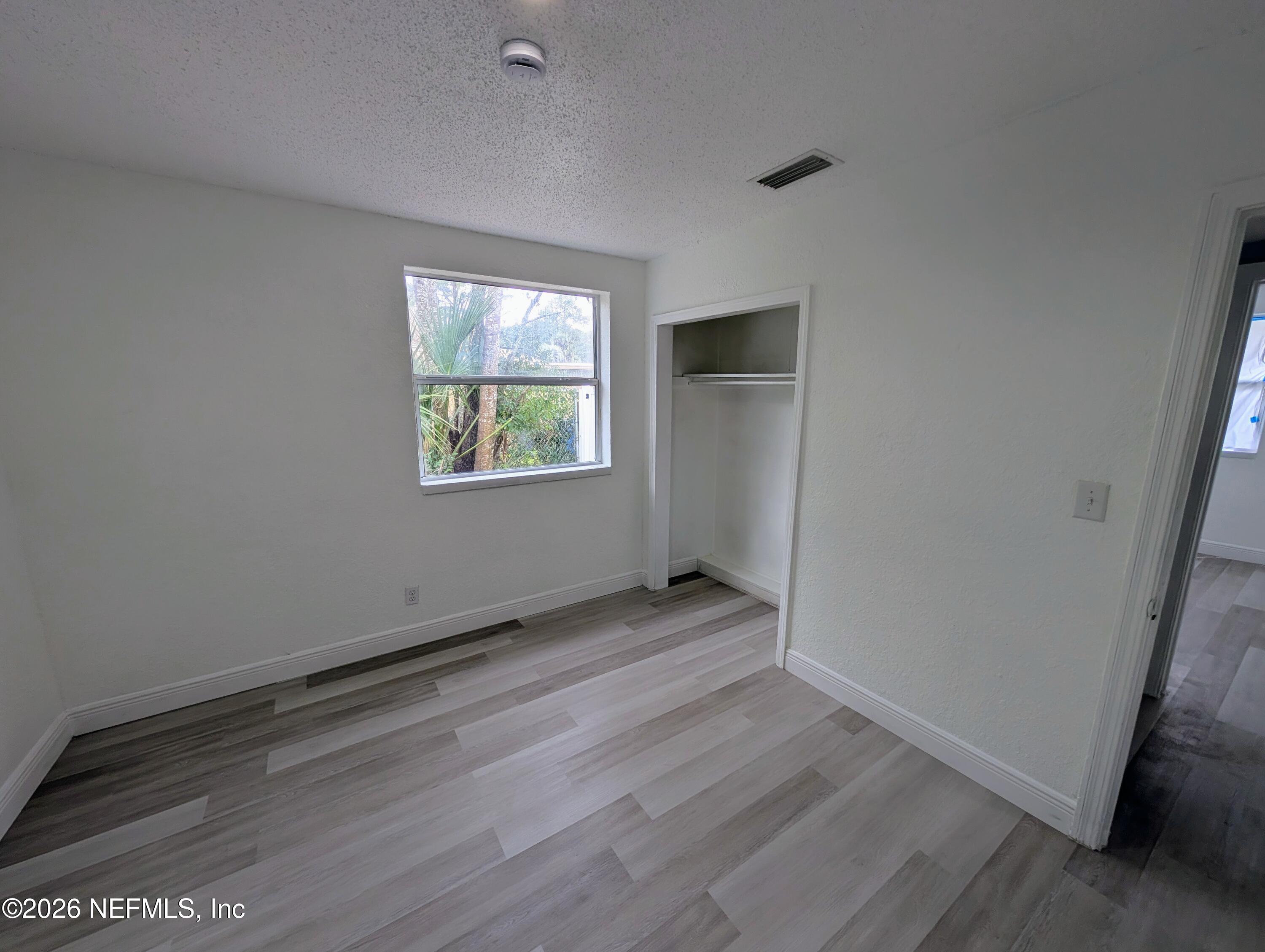 1454 Ribault Scenic Drive Jacksonville, FL 32208 - Photo 9 of 22 an empty room with wooden floor and windows