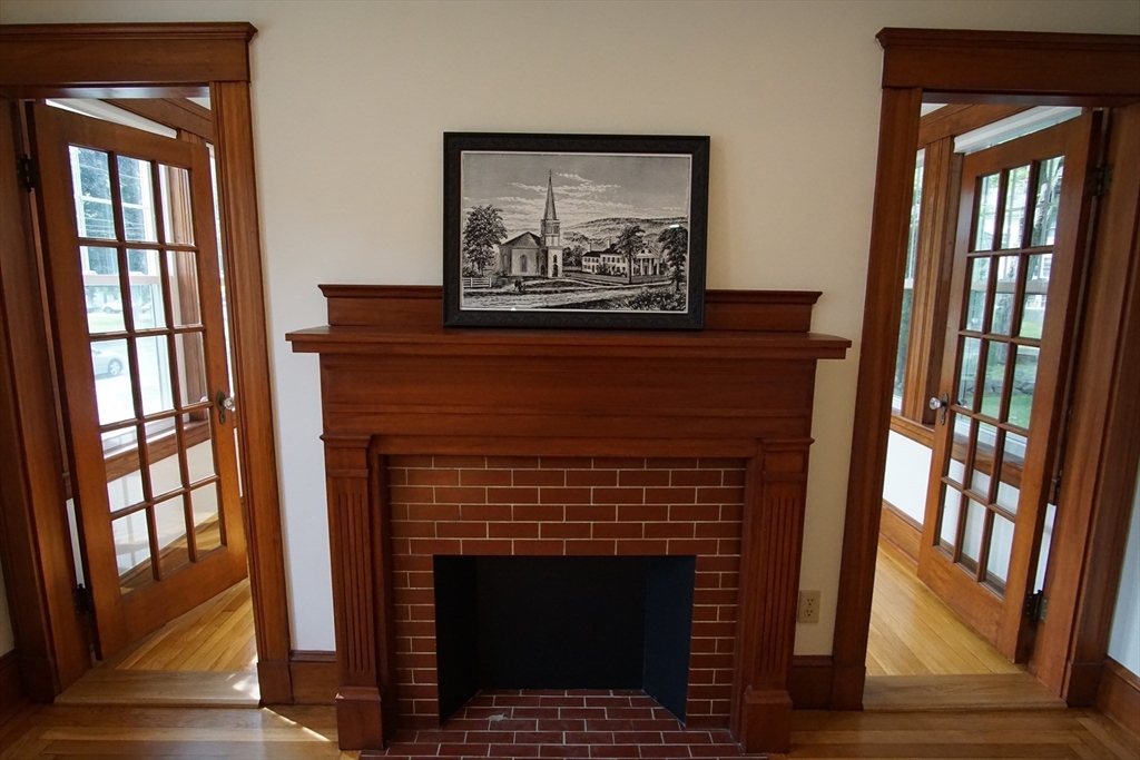 754 Massachusetts Avenue, Unit 1 Lexington, MA 02421 - Photo 3 of 17 a living room with a fireplace and a floor to ceiling window