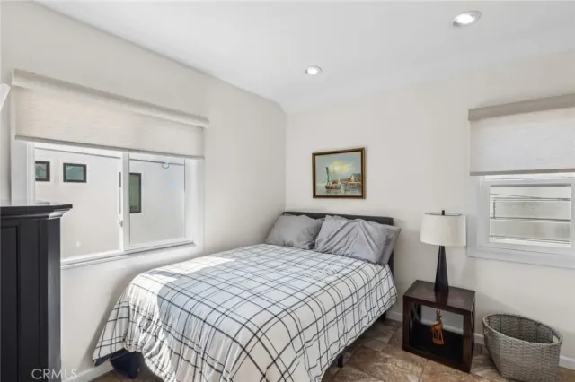 a bedroom with a bed and a lamp on dresser