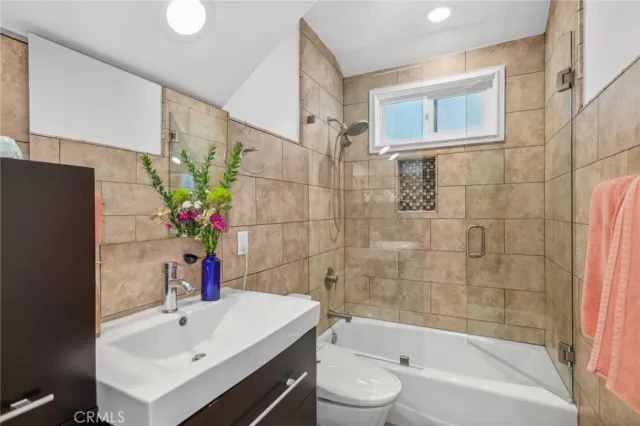 a white bath tub sitting next to a white sink and a mirror