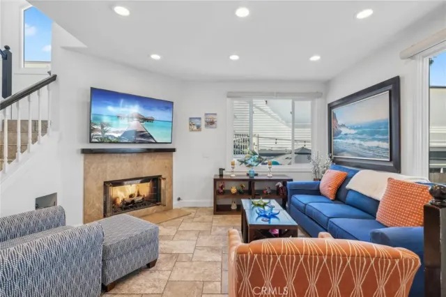a living room with furniture a fireplace and a large window