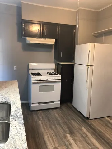 a white refrigerator freezer and a stove sitting inside of a kitchen