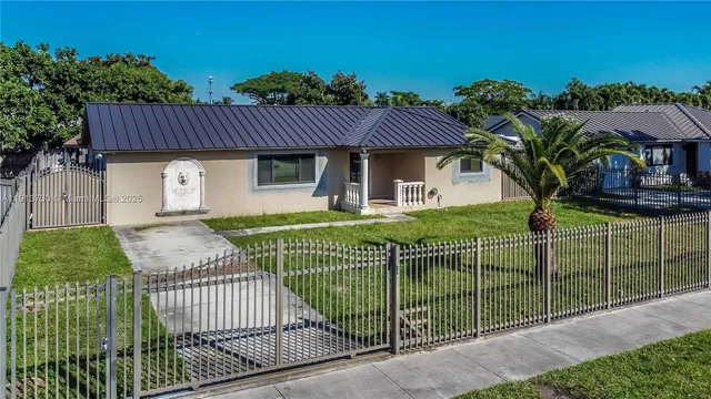 a view of a house with a fence and a garden