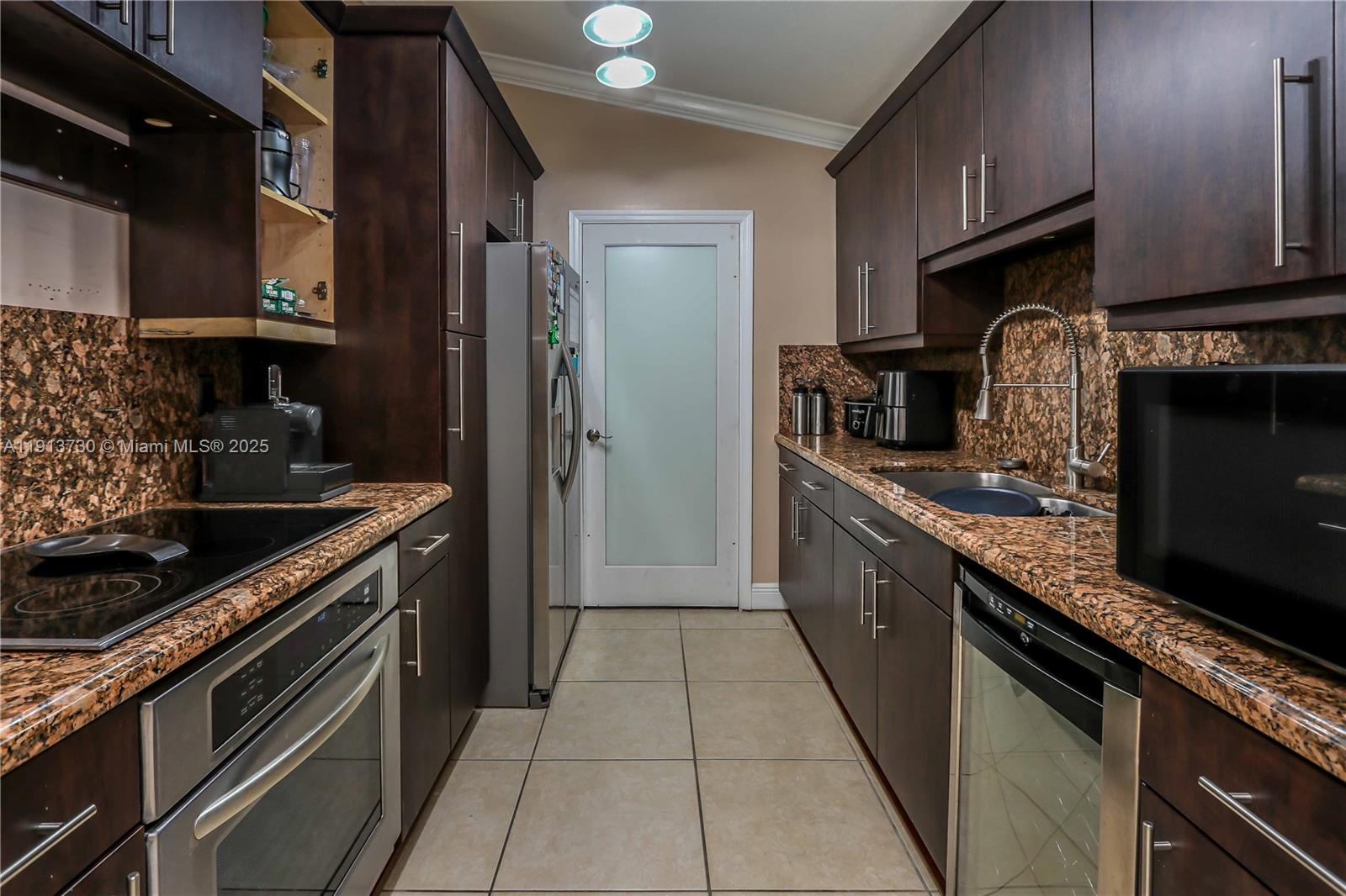 11617 Southwest 171st Street Miami, FL 33157 - Photo 13 of 23 a kitchen with stainless steel appliances granite countertop a stove a sink and a refrigerator