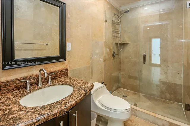 a bathroom with a granite countertop sink toilet and shower