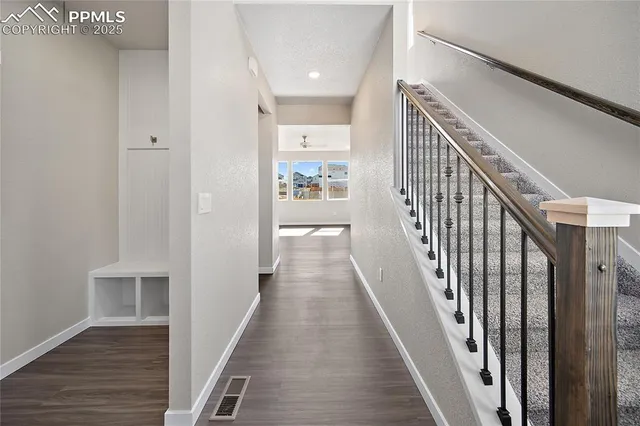 a view of a hallway with wooden floor and staircase