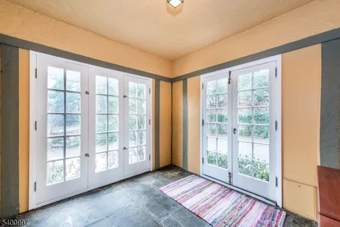 a view of an empty room with wooden floor and windows