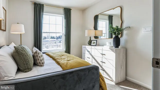 a bedroom with a bed a mirror and a window