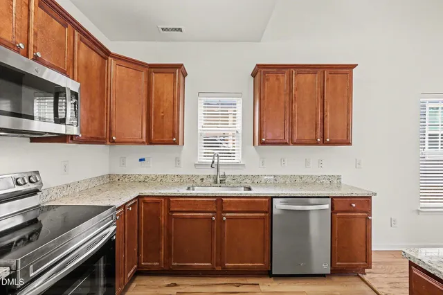 a kitchen with stainless steel appliances granite countertop a sink stove and cabinets