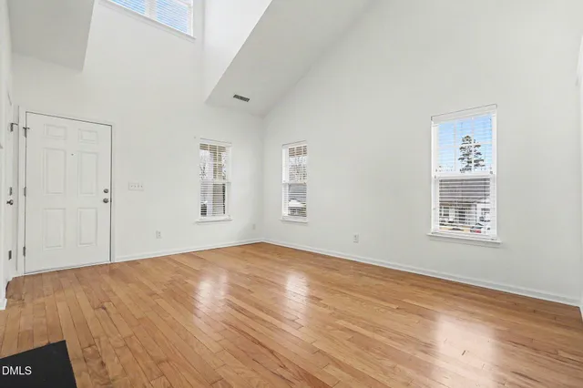 a view of empty room with wooden floor