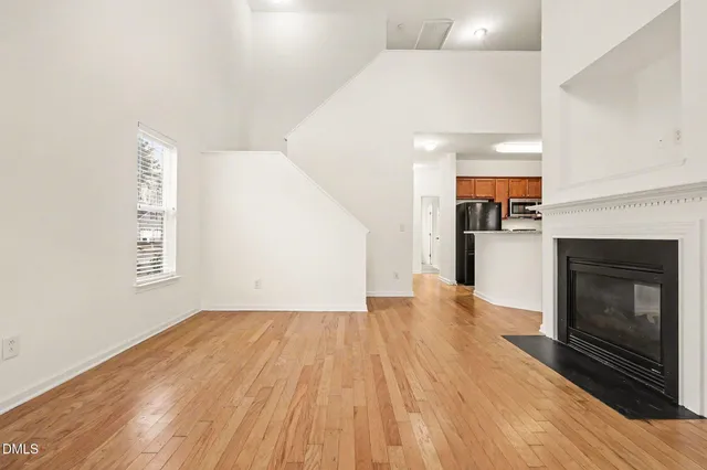 a view of empty room with wooden floor and fireplace