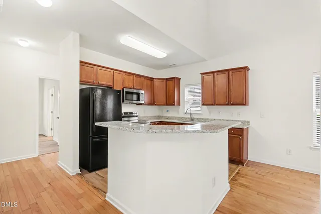 a kitchen with stainless steel appliances granite countertop a refrigerator stove and microwave