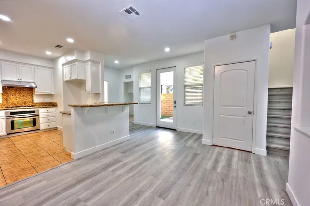 a kitchen with stainless steel appliances granite countertop a refrigerator and a stove top oven