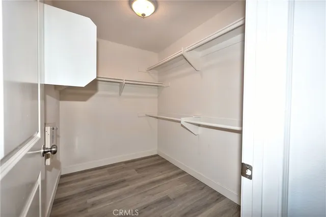 a view of an empty walk in closet with wooden floor