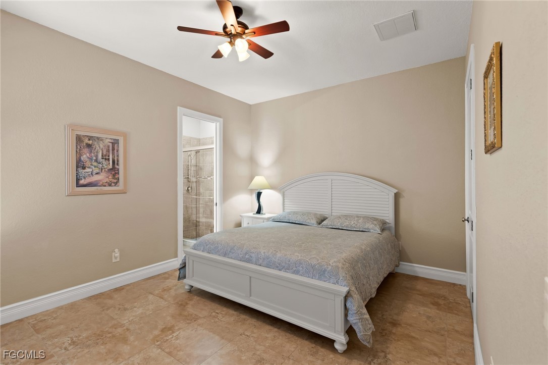 6057 Calusa Rdg Trail Bokeelia, FL 33922 - Photo 21 of 44 a bedroom with a bed and a chandelier