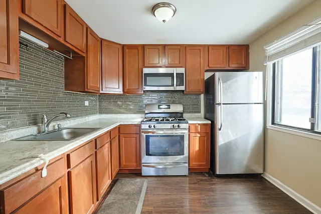 a kitchen with stainless steel appliances granite countertop a refrigerator stove and sink