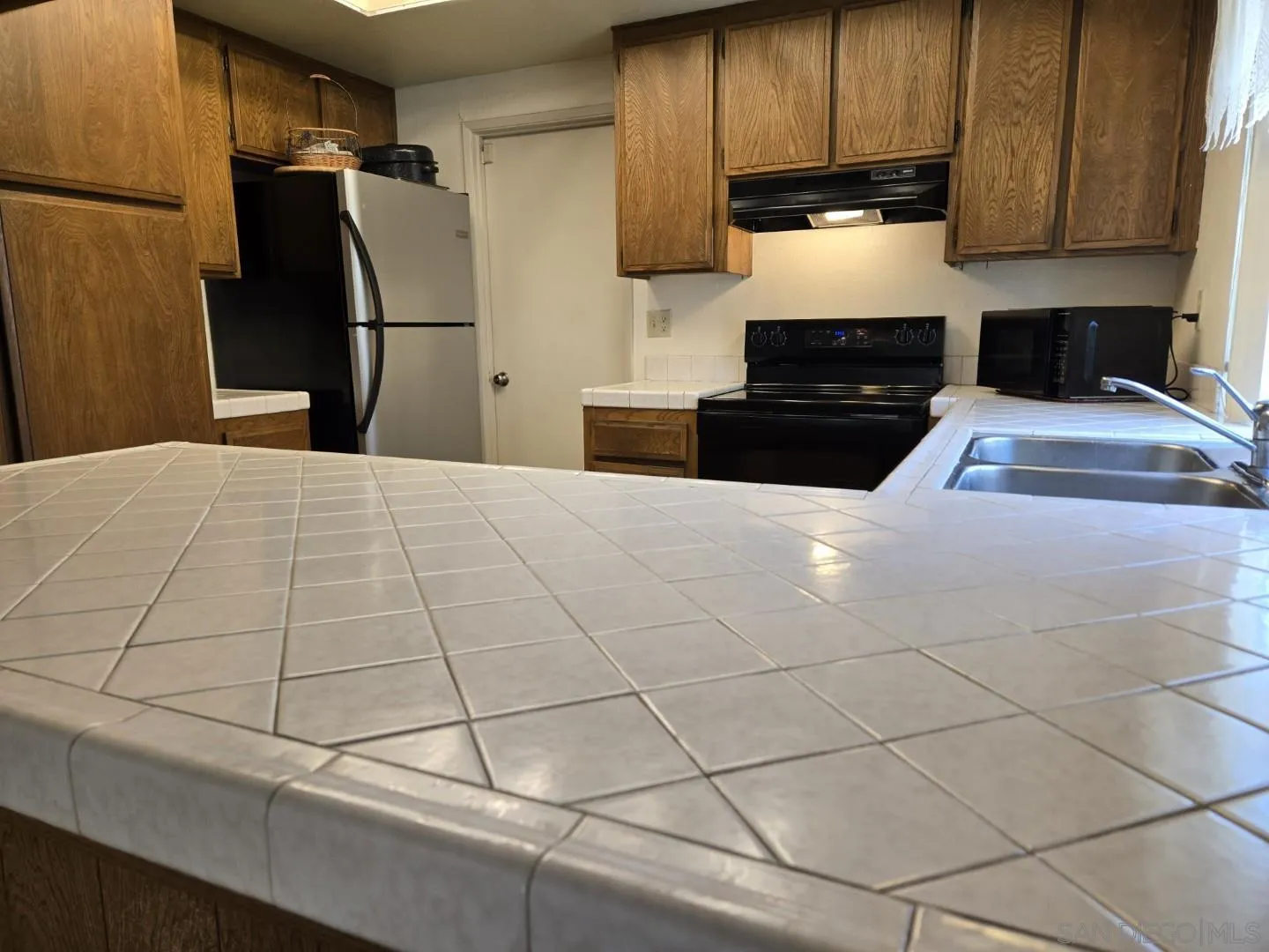 9343 Lake Hill Road Santee, CA 92071 - Photo 7 of 23 a kitchen with stainless steel appliances a refrigerator sink and cabinets