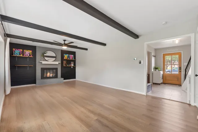 a view of a hallway with wooden floor and a bedroom