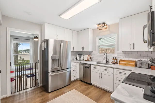 a kitchen with stainless steel appliances granite countertop a refrigerator and a sink
