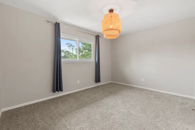 an empty room with wooden floor and window