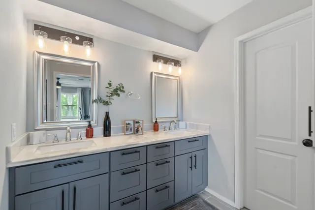 a bathroom with a double vanity sink and a mirror