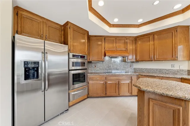 a kitchen with granite countertop stainless steel appliances and wooden cabinets