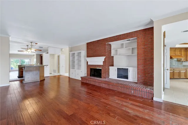 a view of a livingroom with wooden floor and a fireplace