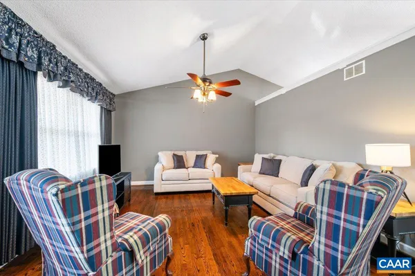a living room with furniture a flat screen tv and a window
