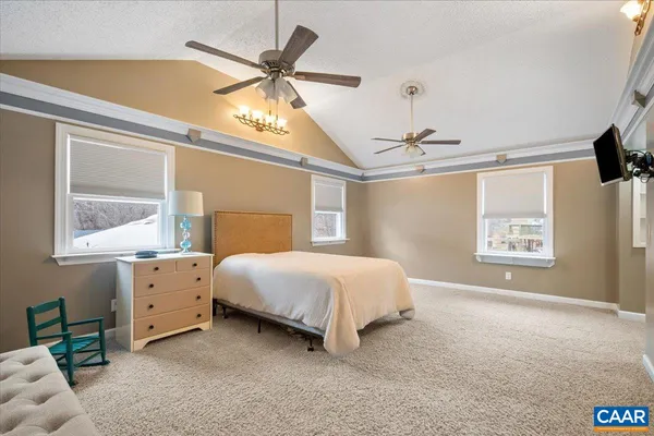 a spacious bedroom with a large bed and a chandelier