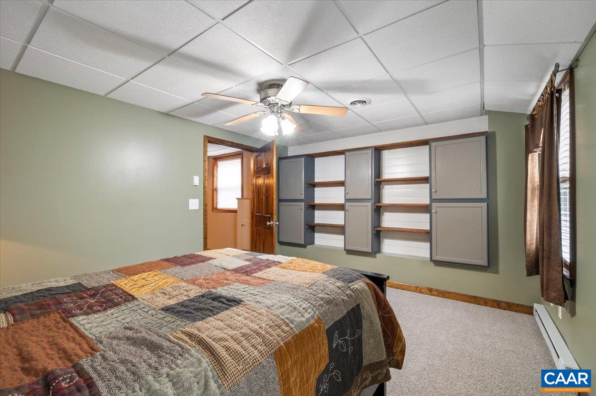 716 Preddy Creek Road Barboursville, VA 22923 - Photo 49 of 73 a spacious bedroom with a large bed and a chandelier