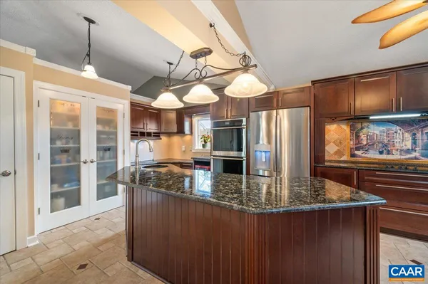 a kitchen with stainless steel appliances granite countertop a sink a oven and a refrigerator