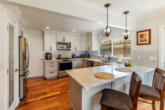 a kitchen with granite countertop stainless steel appliances and sink