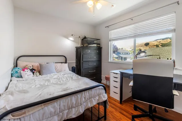 a spacious bedroom with a bed and wooden floor