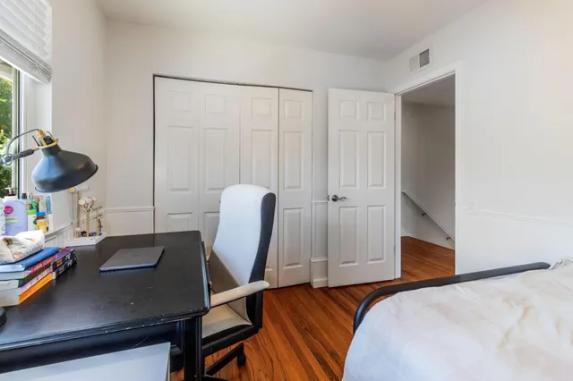 a bedroom with a bed and wooden floor