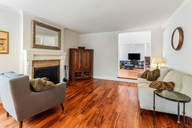 a kitchen with stainless steel appliances granite countertop a sink a stove a refrigerator cabinets a dining table and chairs