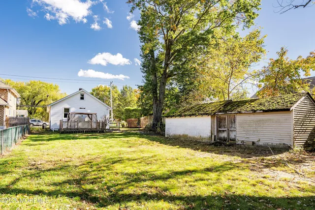 a view of a house with backyard and sitting area