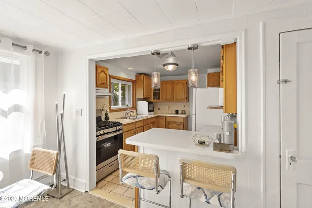 a large kitchen with a table chairs refrigerator and cabinets
