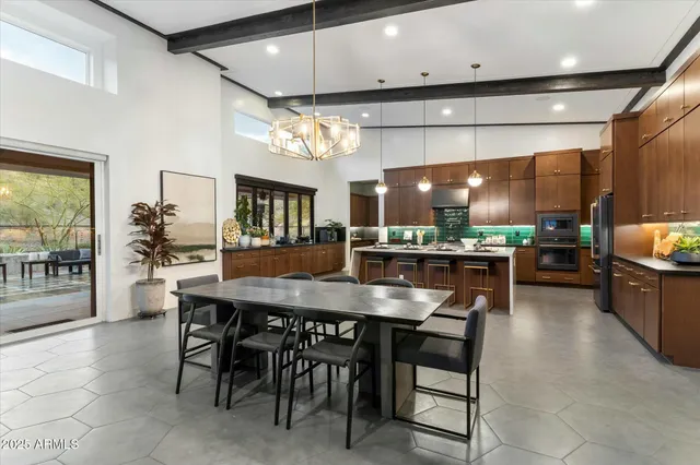 a kitchen with a dining table chairs and wooden floor