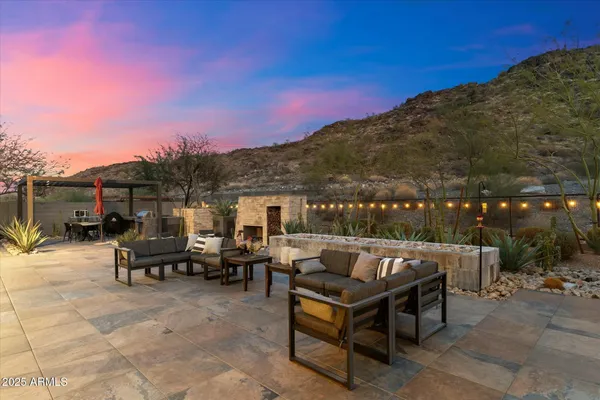 a view of a patio with couches table and chairs with wooden floor and fence