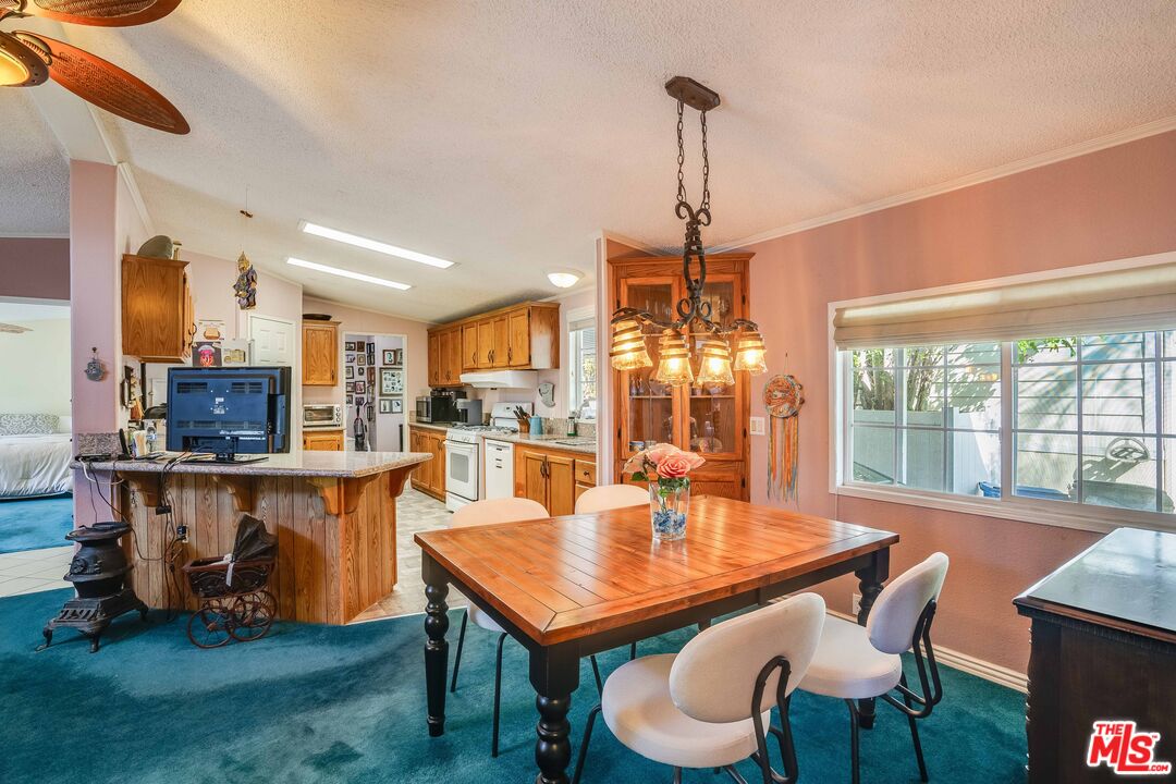 1111 Cherokee Topanga, CA 90290 - Photo 3 of 21 a dining room with wooden floor a chandelier a wooden table and chairs