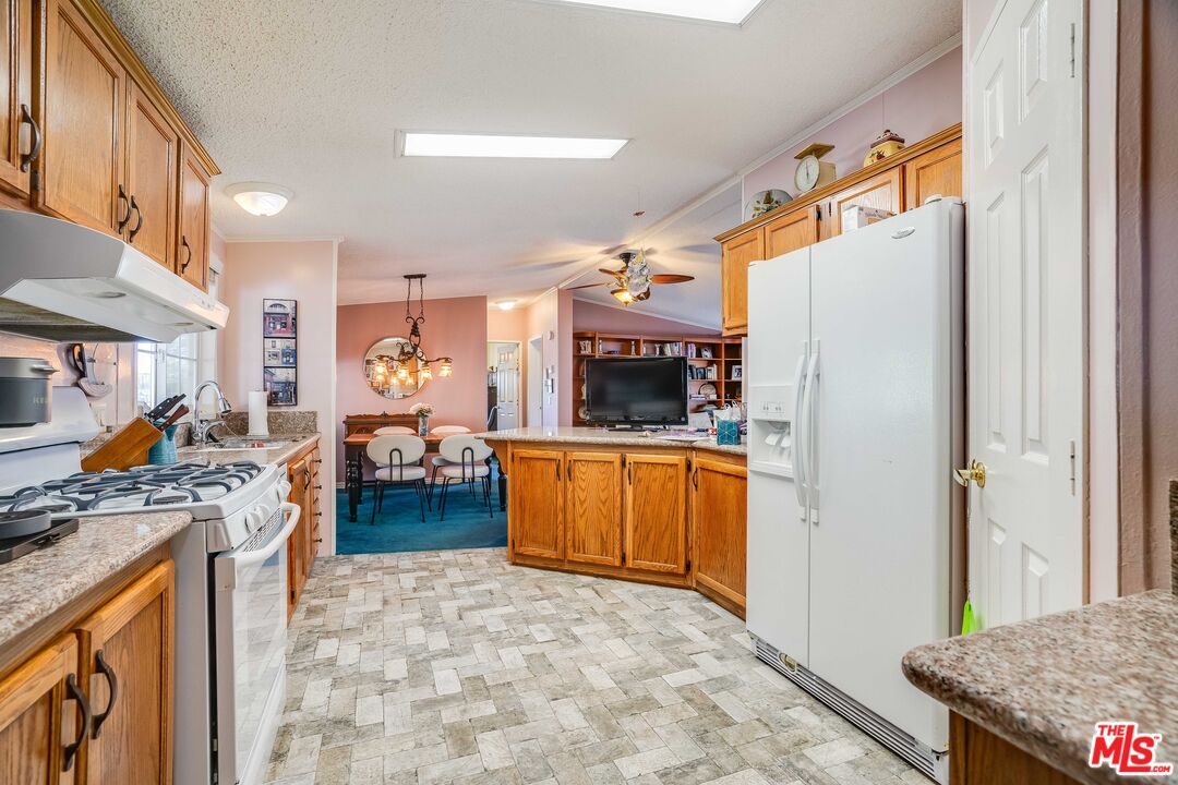 1111 Cherokee Topanga, CA 90290 - Photo 4 of 21 a kitchen with stainless steel appliances granite countertop a refrigerator a stove and a sink with wooden floor
