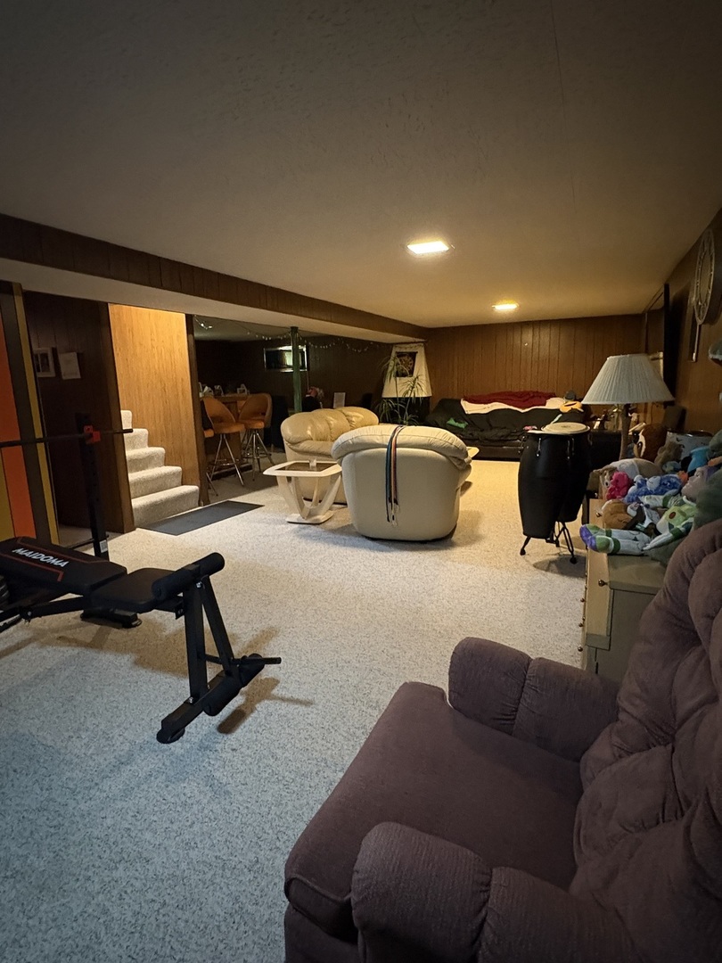 170 Cherrywood Road Buffalo Grove, IL 60089 - Photo 7 of 8 a living room with furniture a flat screen tv and gym equipment