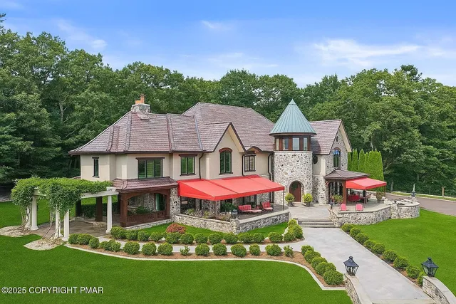 a front view of a house with a yard and trees