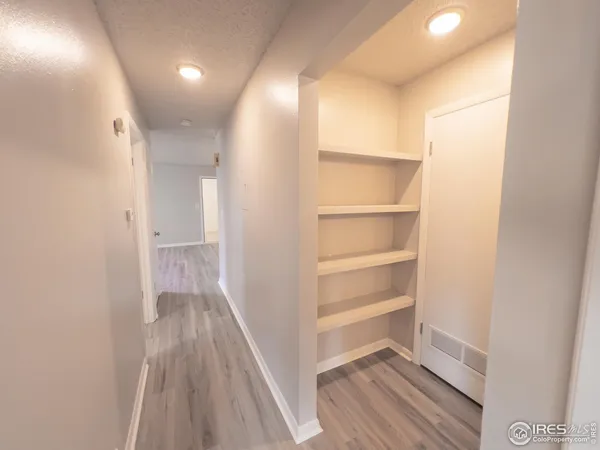 a view of a hallway with wooden floor and entryway