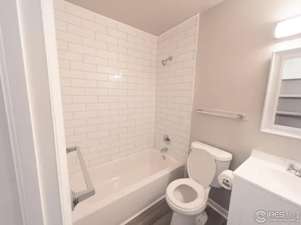 a white toilet sitting next to a bath tub